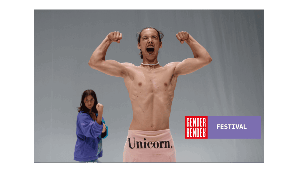 Un performer a torso nudo al centro della scena urla e mostra i muscoli con le braccia sollevate, indossando una felpa rosa legata in vita con la scritta 'Unicorn.'. Sullo sfondo, una persona in abiti casual lo osserva in posa simile. In basso a destra il logo di Gender Bender.